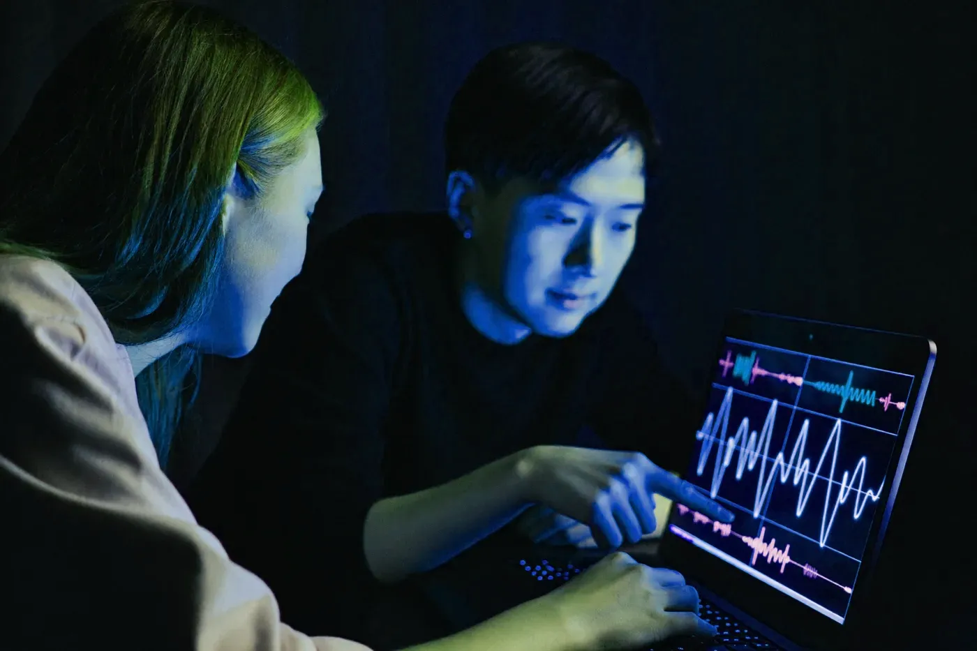Two students reading live brainwave signals on a laptop
